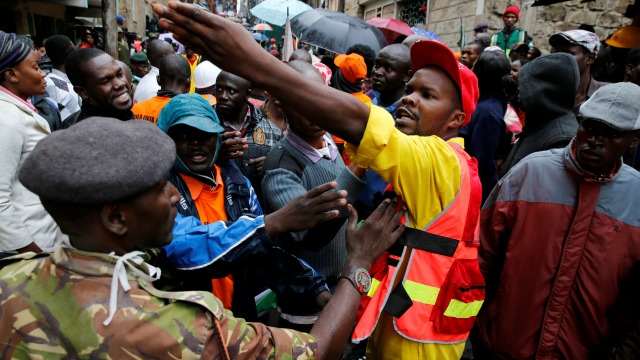 Rescue workers react during the search for residents feared trapped in the rubble of a six-storey building that collapsed after days of heavy rain in Nairobi, Kenya, May 1, 2016. REUTERS/Thomas Mukoya